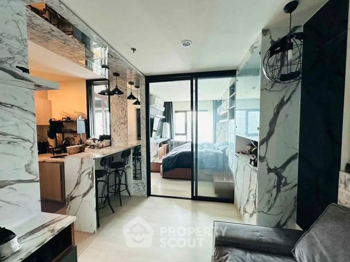 Modern apartment with marble accents and open layout, featuring a cozy living area and stylish kitchen.