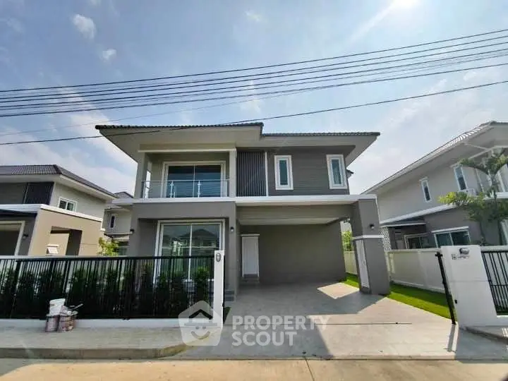 Modern two-story house with spacious driveway and sleek exterior design.
