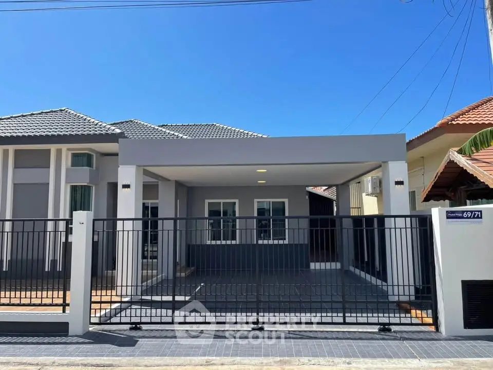 Modern single-story house with sleek design and spacious driveway under clear blue sky.