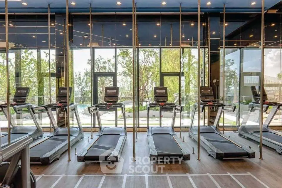 Modern gym with treadmills and large windows offering scenic views