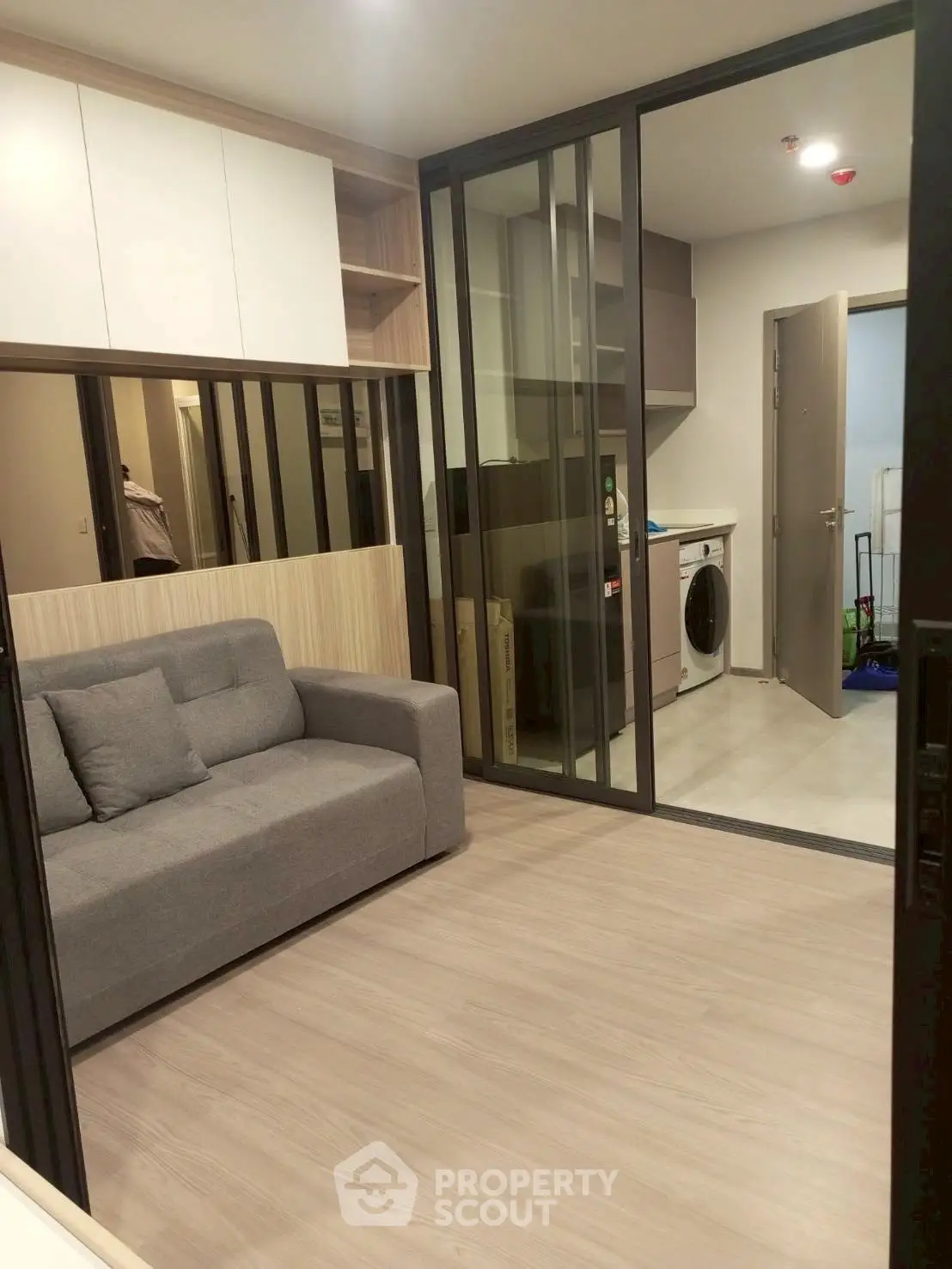 Modern apartment with open layout featuring a cozy living room and sleek kitchen area.