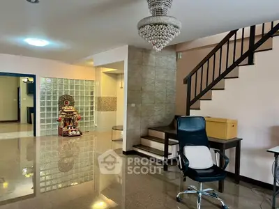Spacious modern living area with elegant staircase and office setup