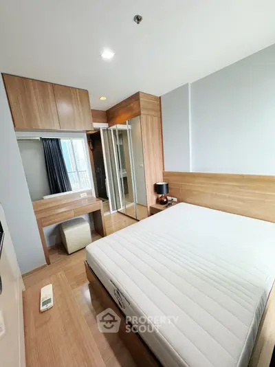 Modern bedroom with wooden accents and mirrored wardrobe in a stylish apartment.