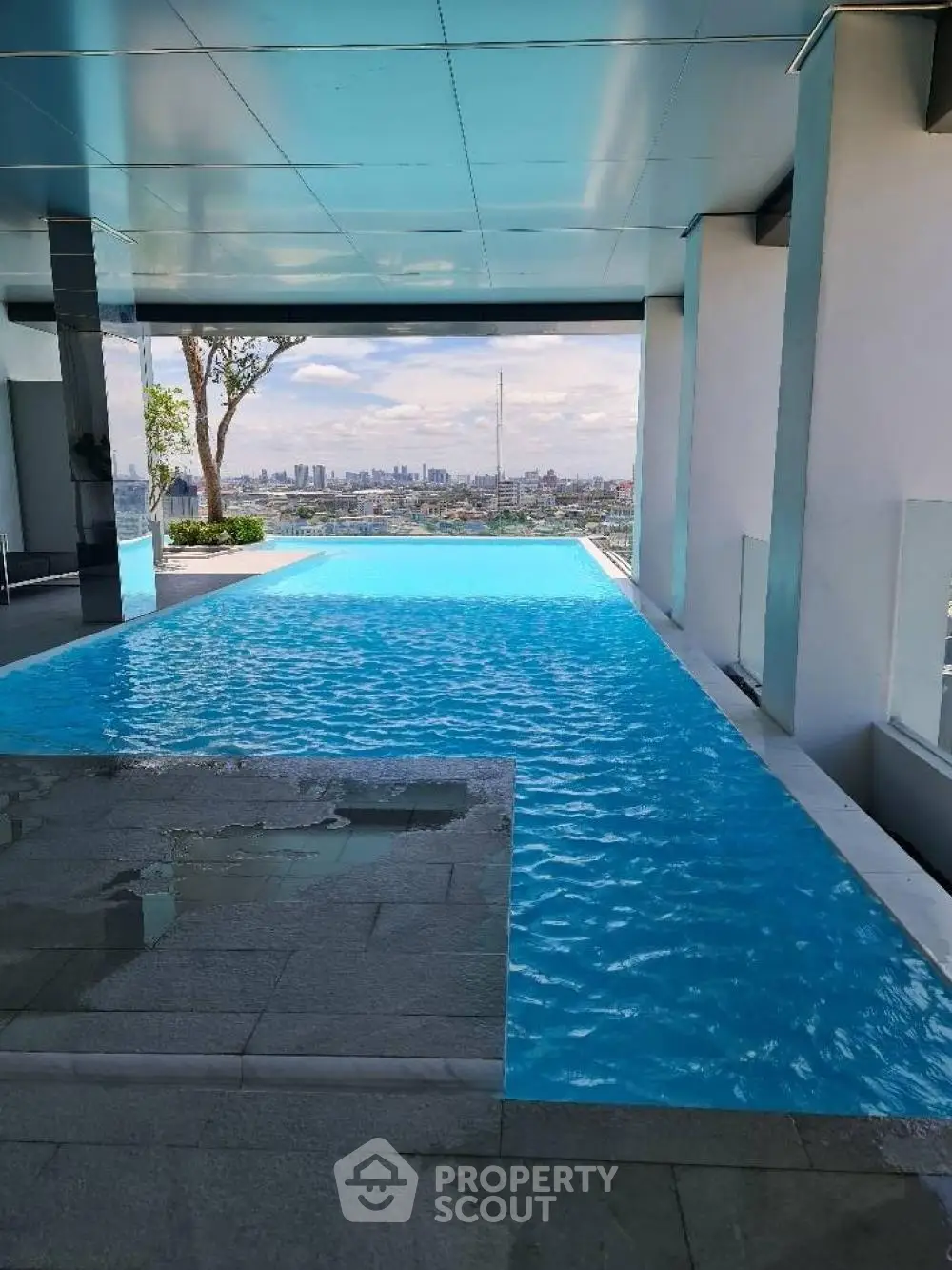 Luxurious rooftop infinity pool with stunning city skyline view, perfect for relaxation and entertainment.