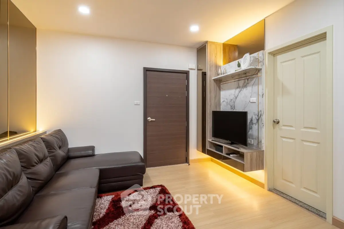 Modern living room with sleek leather sofa and built-in TV unit, featuring warm lighting and stylish decor.