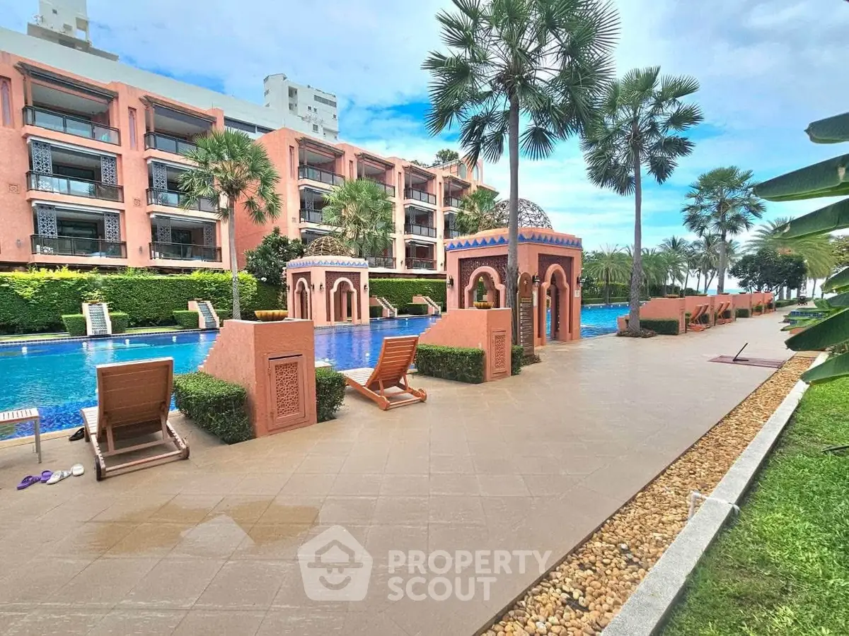 Luxurious poolside view with palm trees and elegant architecture in a tropical resort setting.