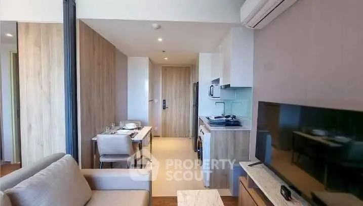 Modern open-plan living room with kitchen and dining area in a stylish apartment.