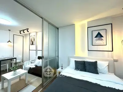 Modern studio apartment with stylish decor and sliding glass partition, perfect for urban living.