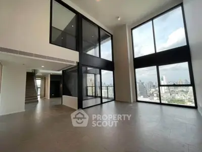 Spacious modern living room with floor-to-ceiling windows and city view