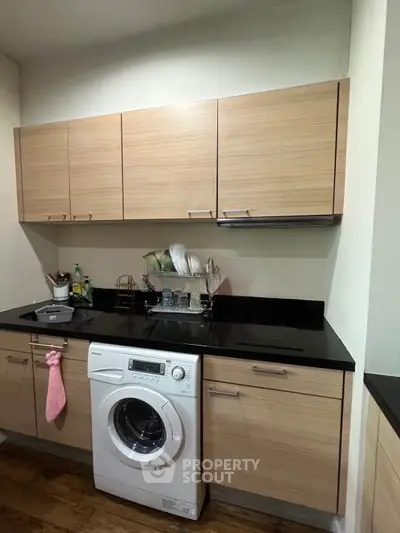 Modern kitchen with wooden cabinets and built-in washing machine
