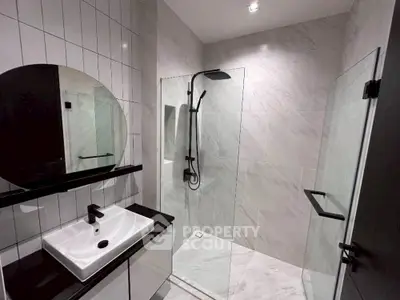 Modern bathroom with sleek shower and stylish vanity in contemporary design.