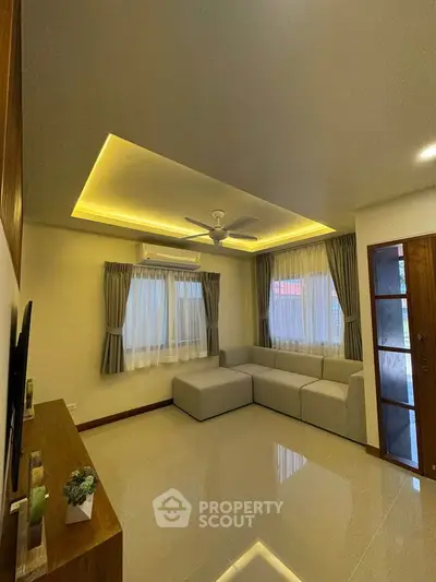 Modern living room with stylish ceiling lights and cozy corner sofa.