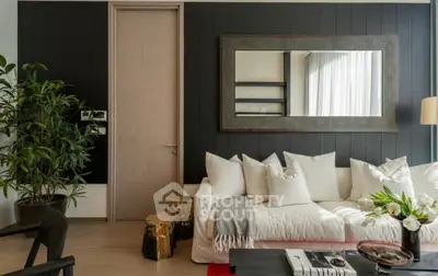 Modern living room with stylish decor, large mirror, and cozy white sofa.