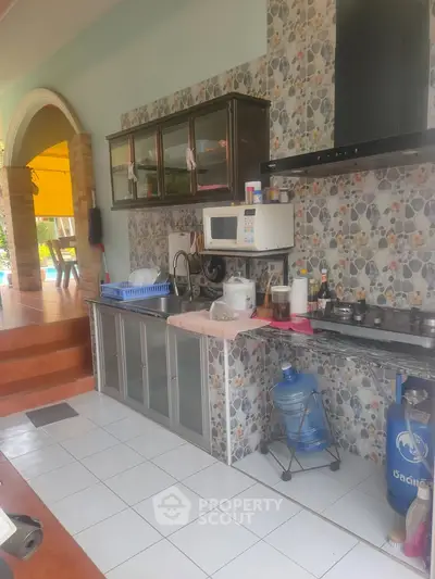 Charming open-layout kitchen with modern appliances and stylish stone backsplash