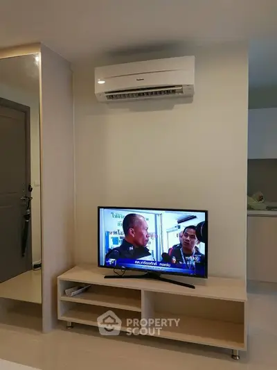 Modern living room with air conditioning and TV setup in a stylish apartment.
