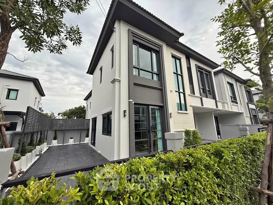 Modern two-story house with sleek design and lush greenery