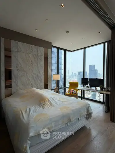 Luxurious bedroom with stunning city view and modern decor in high-rise apartment.