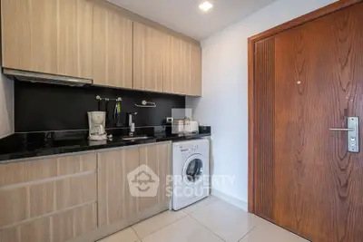 Modern kitchen with wooden cabinets and washing machine in compact layout.