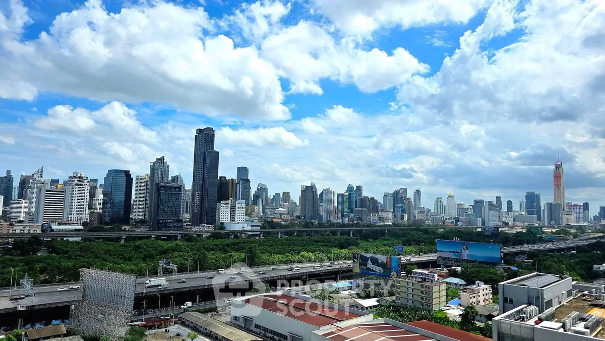 Stunning city skyline view with lush greenery and modern skyscrapers under a vibrant blue sky.