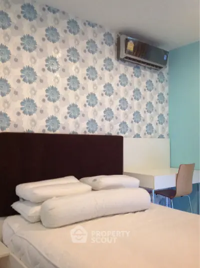 Cozy bedroom with floral wallpaper and modern air conditioning unit