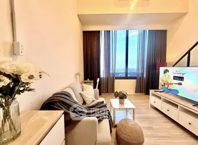 Stylish living room with cozy seating and large window offering stunning city views.