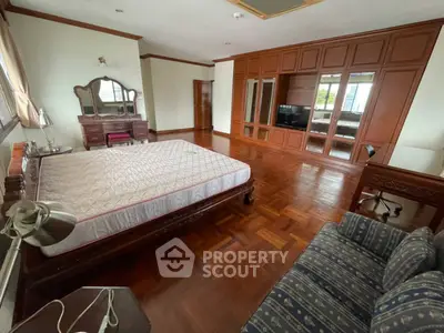 Spacious bedroom with elegant wooden flooring and classic furniture
