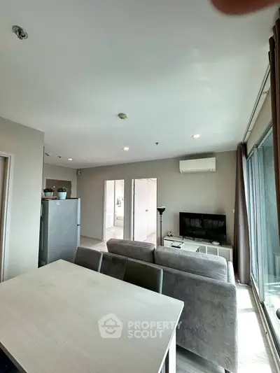 Modern living room with sleek furniture and large windows offering natural light.