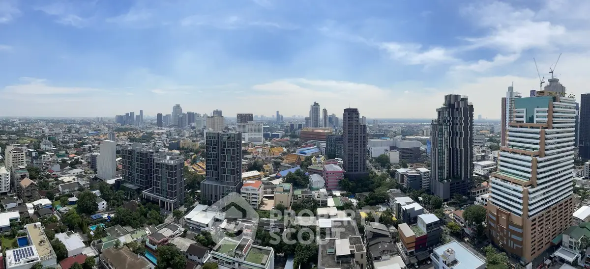 Stunning panoramic cityscape view showcasing modern high-rise buildings and urban skyline under a clear blue sky.