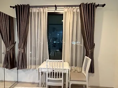 Cozy study nook with elegant curtains and city view