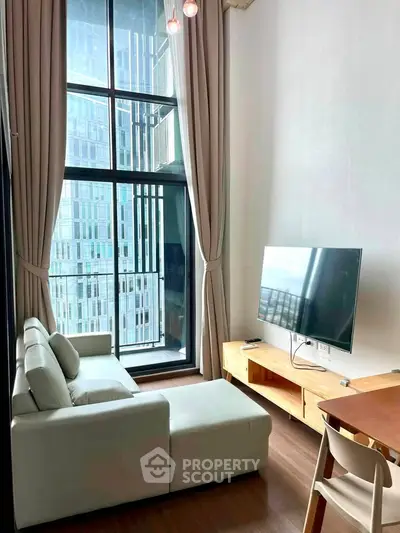 Modern living room with floor-to-ceiling windows and stylish furniture in a high-rise apartment.