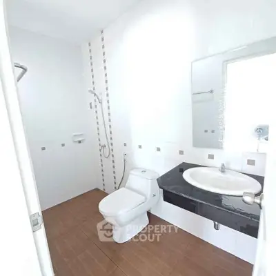 Modern minimalist bathroom with white tiles and sleek fixtures