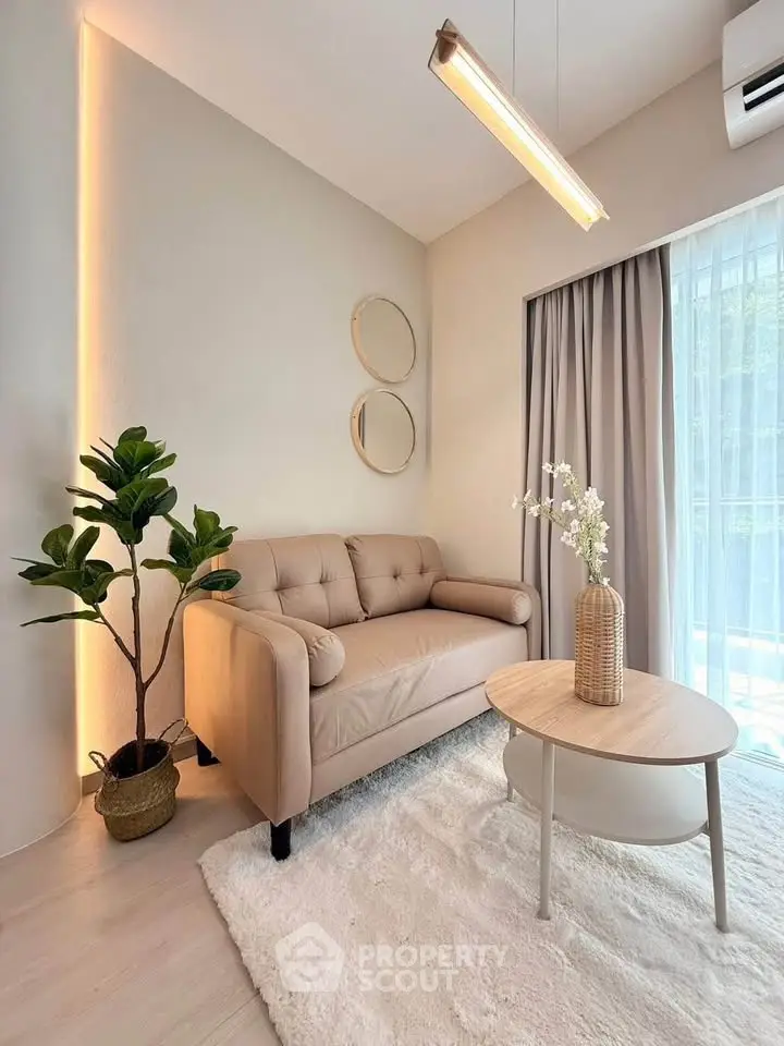 Cozy living room with modern beige sofa, stylish decor, and natural light through large window.