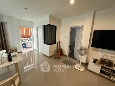 Modern living room with sleek design, featuring a guitar and fan, perfect for cozy gatherings.