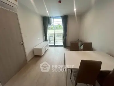 Modern living room with balcony access and minimalist furniture in a bright apartment.