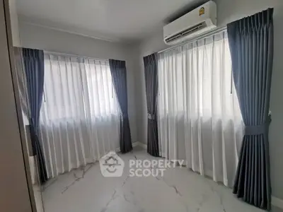 Bright room with large windows and elegant curtains, featuring sleek marble flooring and air conditioning.