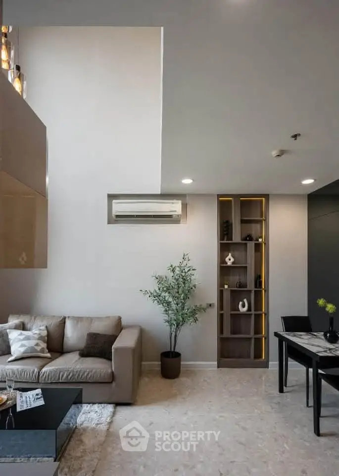 Modern living room with stylish decor and high ceiling, featuring a cozy sofa and elegant shelving.
