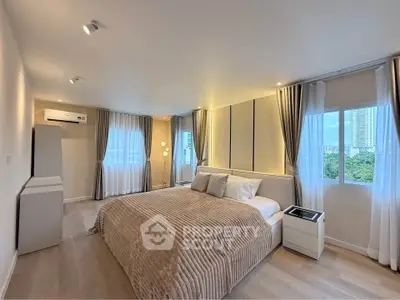 Spacious modern bedroom with large windows and elegant decor