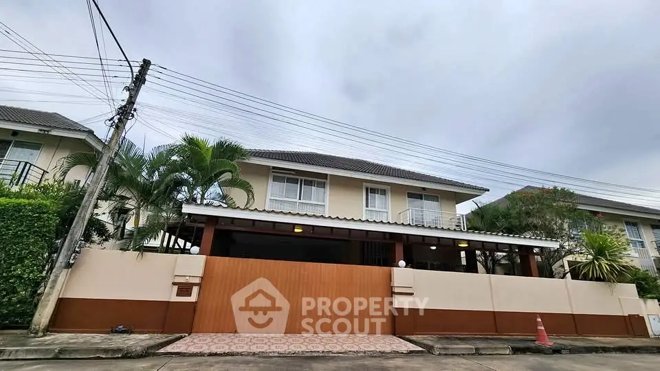 Charming suburban house with lush greenery and secure gated entrance