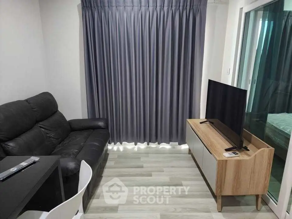 Cozy living room with modern sofa and TV, perfect for relaxation.