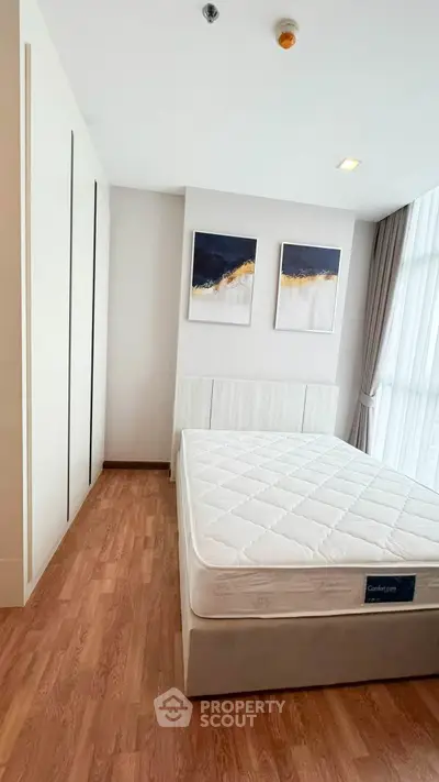 Modern bedroom with stylish decor and large window for natural light