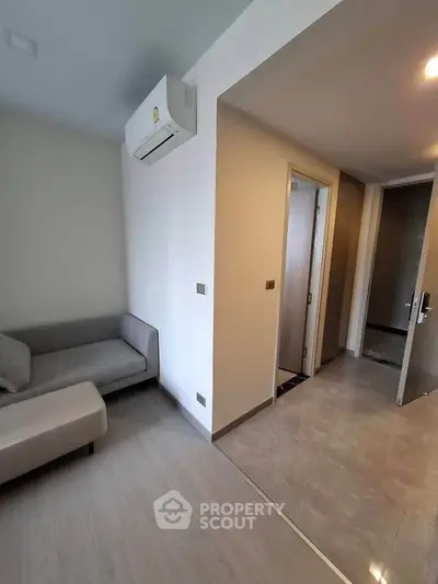 Modern apartment interior with sleek design and air conditioning, featuring a cozy living area and hallway.