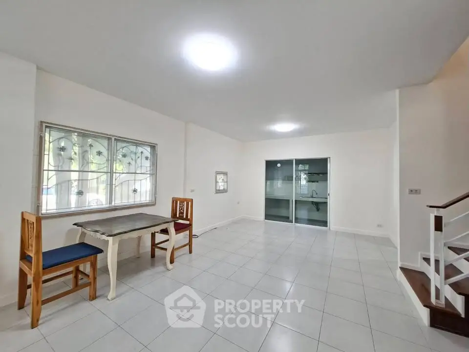 Spacious living room with large windows and modern tile flooring