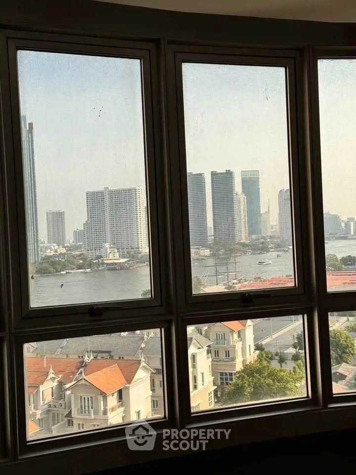 Stunning cityscape view from a high-rise window overlooking river and skyline, perfect for urban living.