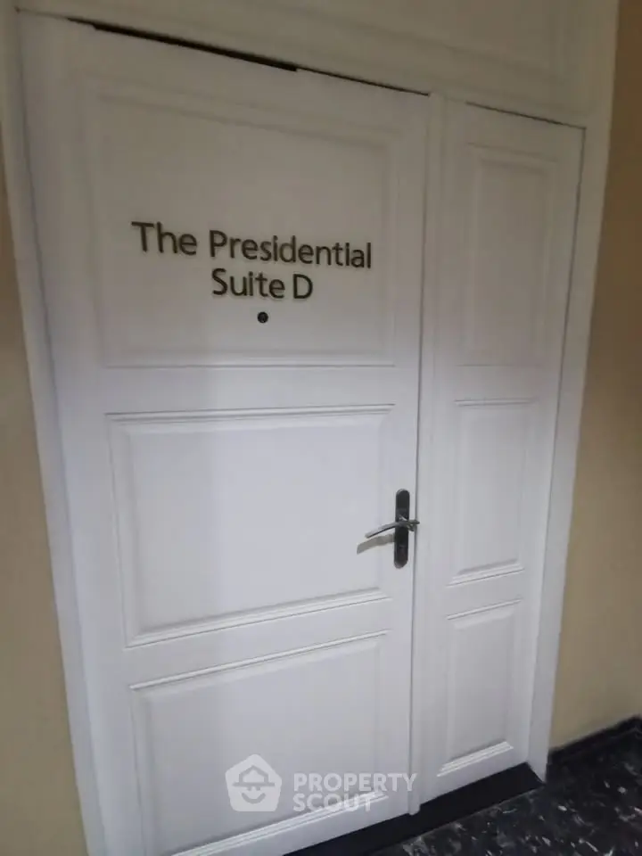 Elegant entrance to The Presidential Suite D with white double doors.