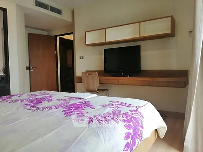 Modern bedroom with wall-mounted TV and stylish wooden desk