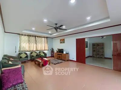 Spacious living room with elegant decor and ceiling fan, perfect for relaxation.