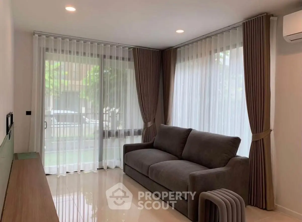 Modern living room with large windows and elegant curtains