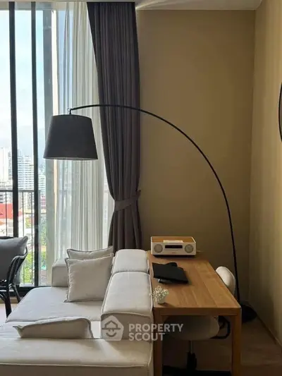 Modern living room with stylish furniture and city view through large windows.
