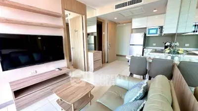 Modern living room with open kitchen, featuring sleek furniture and appliances in a stylish apartment.