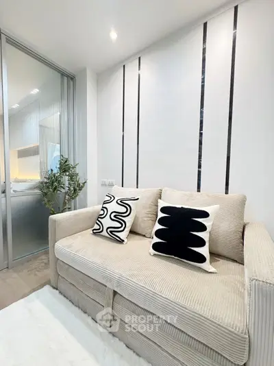 Modern living room with stylish sofa and decorative pillows in a cozy apartment setting.